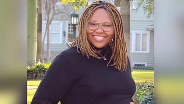 A portrait of a woman smiling at the camera.