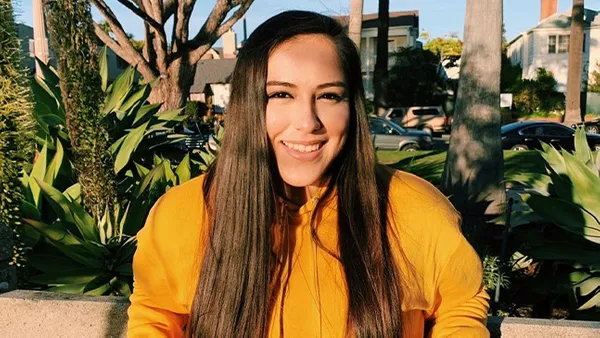 A portrait of a woman smiling at the camera.