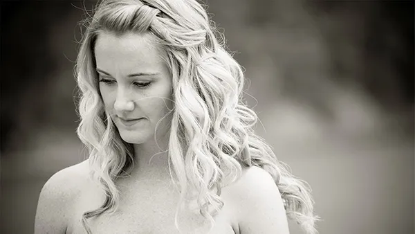A black and white image of a woman looking down.