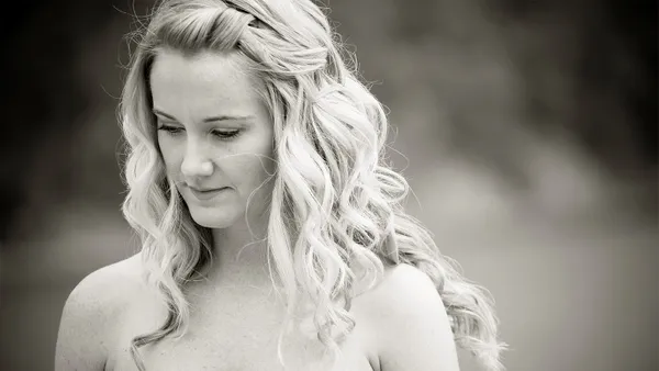 A black and white image of a woman looking downwards.