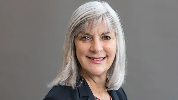 A portrait of a woman smiling at the camera.