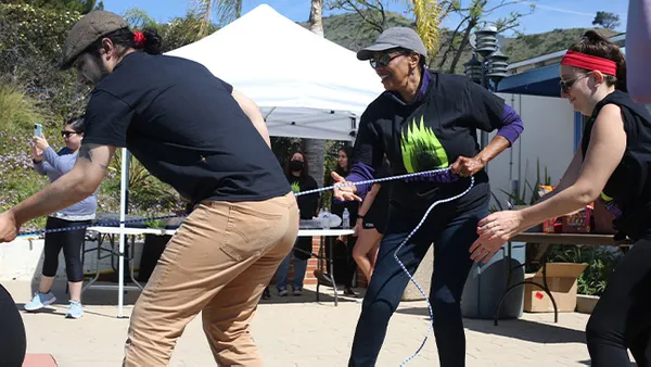 A popular event is the pool float pull, in which teammates pull one member across the length of the pool on a float -- but beware of tipping them over! In this photo, left to right, a friend of one of the students; Linda McMurdock, PhD, vice president of student affairs; and Alison Halpern, RD, CHES, associate director of wellness.