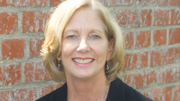 A portrait of a woman smiling at the camera.