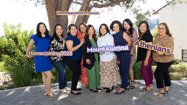 Women holding unstoppable signs and posing under a tree