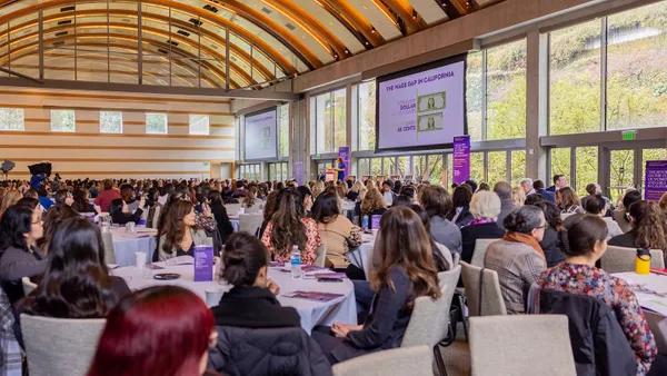 The main hall at the RSWG event filled with people sitting at round tables.