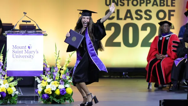 A Mount Saint Mary's University graduate celebrates with joy as she crosses the stage at the undergraduate commencement ceremony.