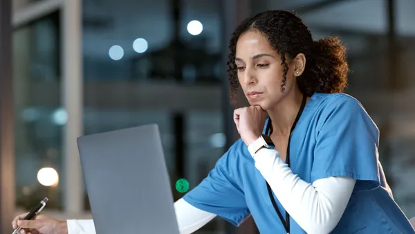 Nurse looking at a laptop. (Above Stock)