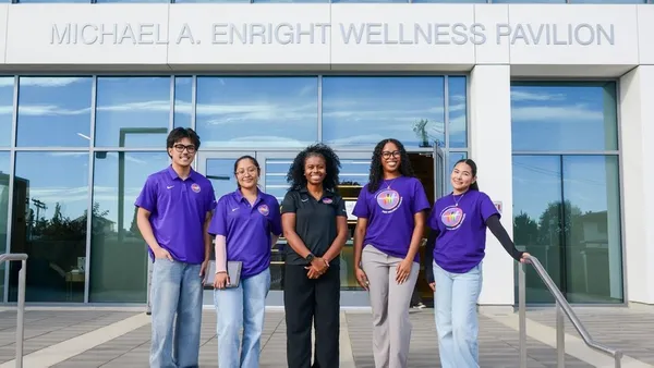 Amelia Mathis, director of sports, recreation and wellness (center), stands with student employees outside the Michael A. Enright Wellness Pavilion.