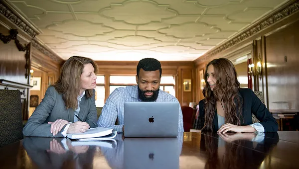 two women and a man working together at a table