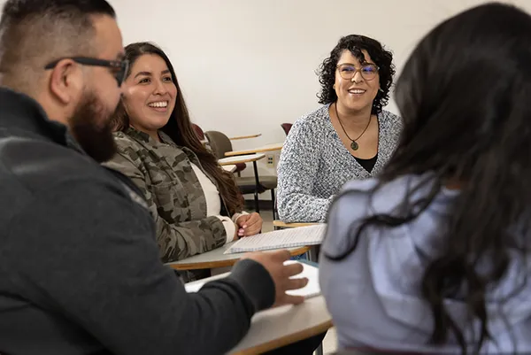 a group of students sitting in a circle in a classroom talking