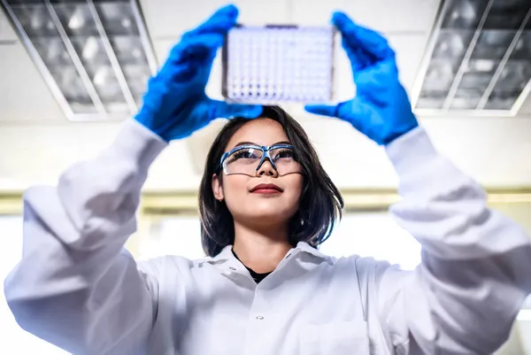Student holding wells plate