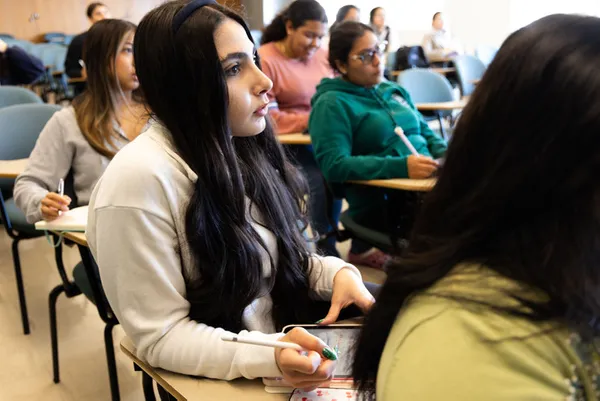 students sitting in a classroom listening