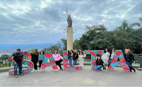 group of students standing in front of a SALTA sign