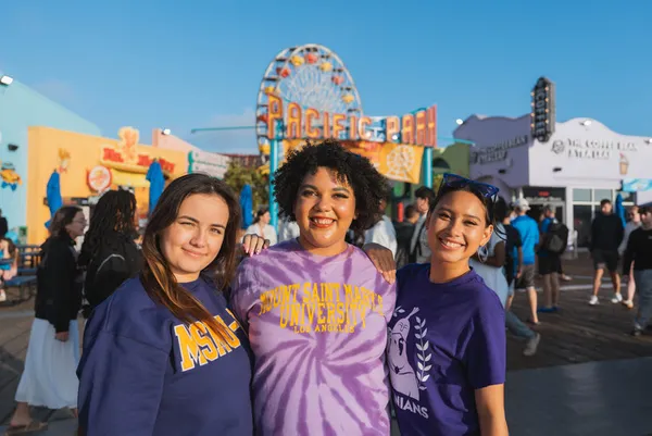 Three �鶹��ý��Ƶ students smiling on the Santa Monica Pier