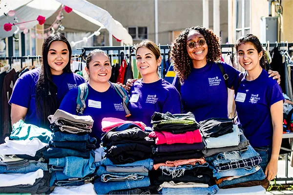 students in purple ˮ���� shirts smiling together