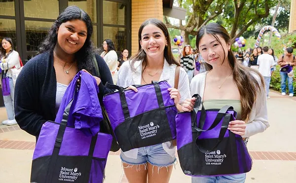 three new students holding up MSMU swag bags smiling