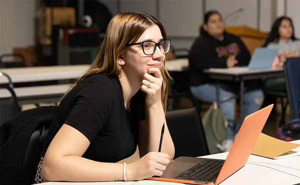 female student smiling and listening in a classroom