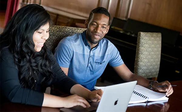 two co-ed graduate students working together at a desk