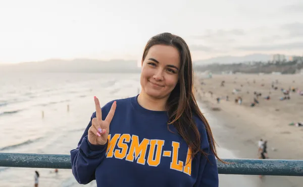 A ˮ���� student giving a peace sign on the LA Pier