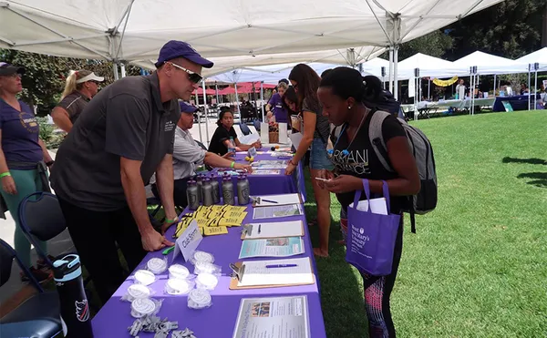 Students speaking with booth attendants about different clubs and organizations at ˮ����.