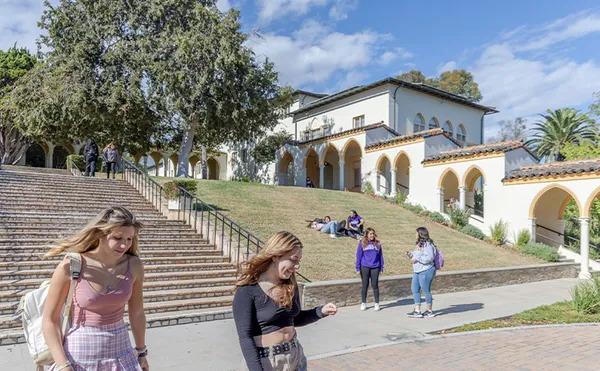 Students walking in front of a set of stairs decending a grassy hill