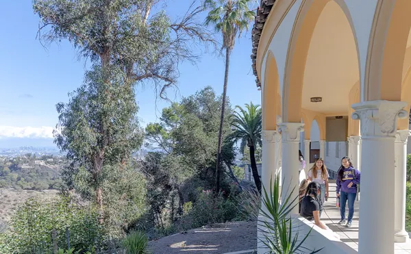 An arched hallway looking out over a tree-filled valley