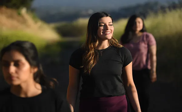 Three students outdoors smiling.
