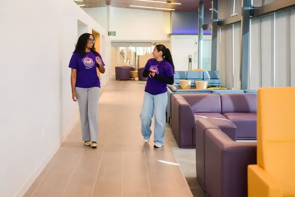 two wellness students walking in a hall chatting