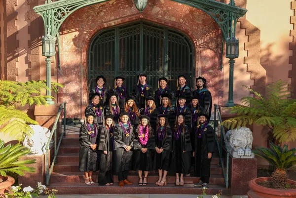 a large group of graduates in robes smiling