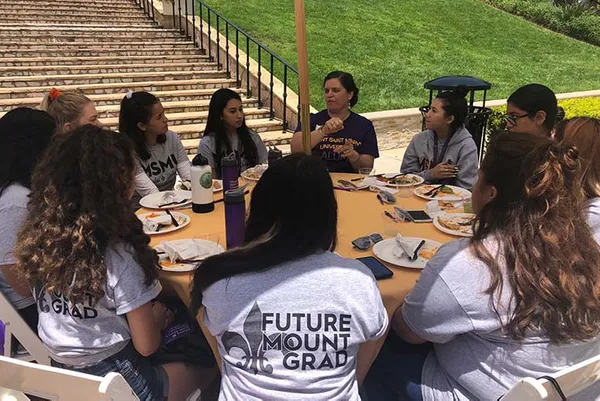 alumnae volunteer talking to students