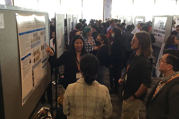 A student discussing research with a group