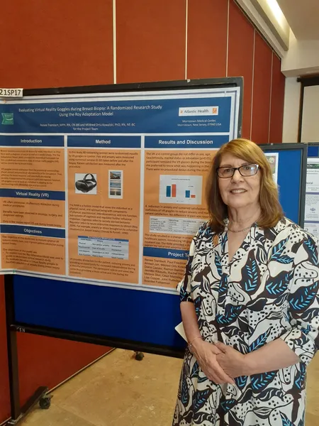 A woman standing next to a presentation board at the conference