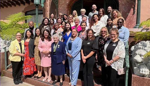 group standing for photo in front of the Doheny Mansion at the Roy Adaptation Association conference