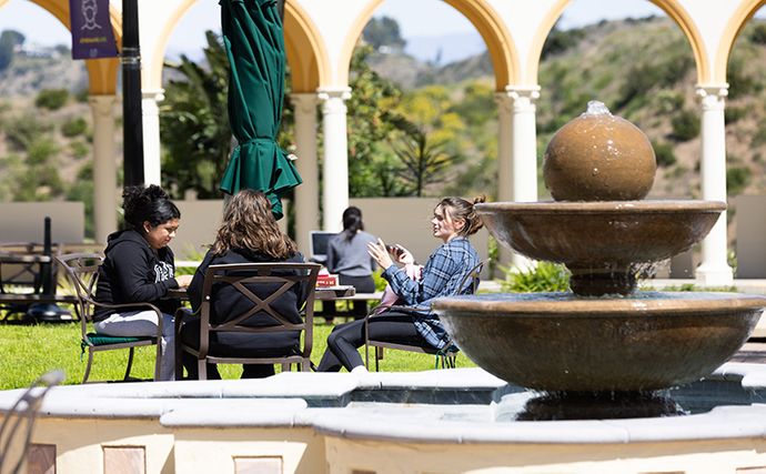 Students sitting near fountain