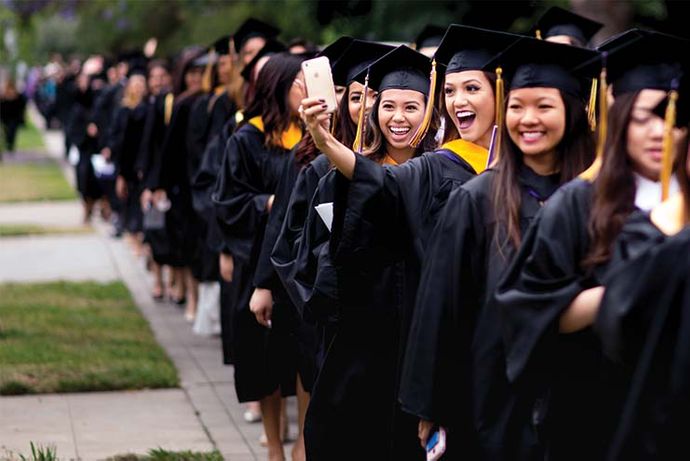 students at commencement taking a selfie
