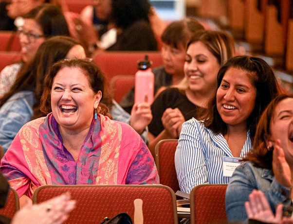 women in audience laughing