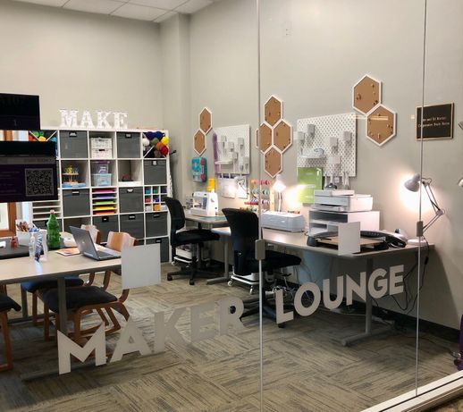 Room filled with crafting supplies and equipment, the words Maker Lounge appear on the windows