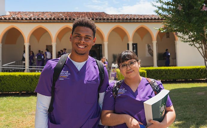 Two 91ɬ�� students smiling on Chalon campus holding books