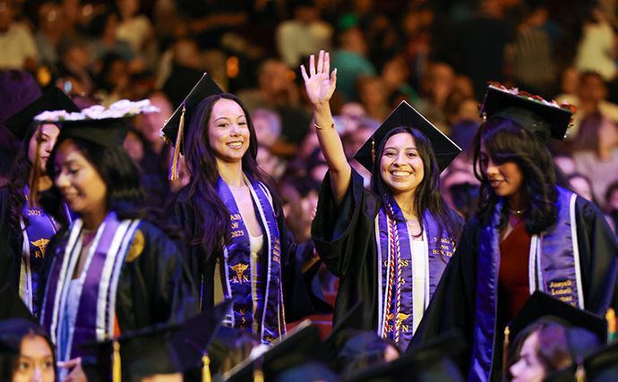 91ɬ�� Graduates walking and waving in the commencement procession