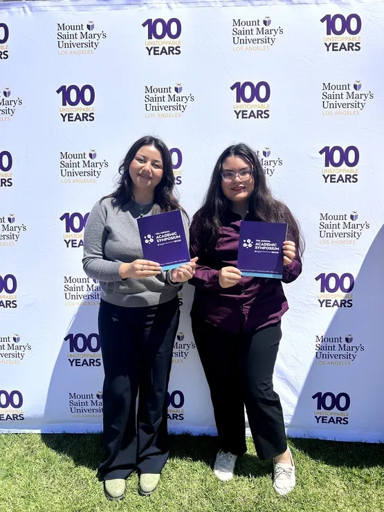 Students pose with symposium programs during Mount Saint Mary’s University’s 13th Annual Academic Symposium at the Chalon Campus.